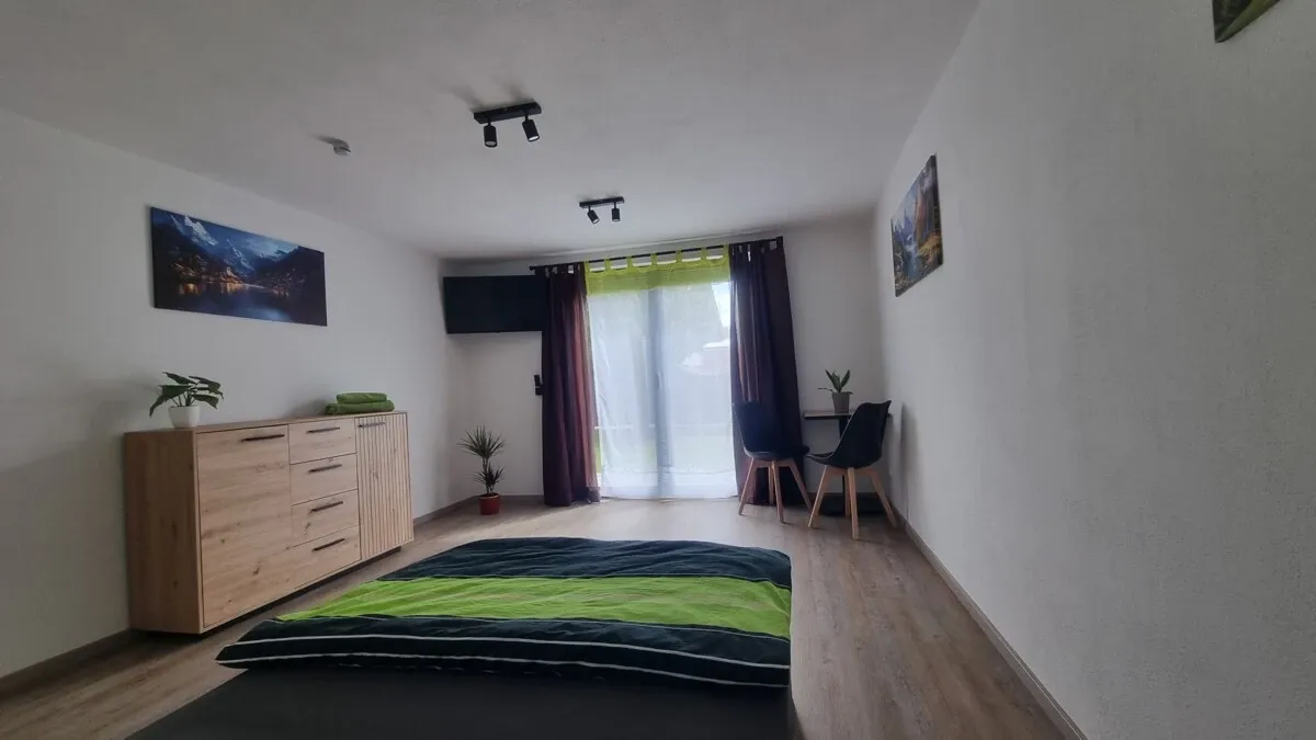 Zimmer mit Doppelbett und Zugang ins Freie