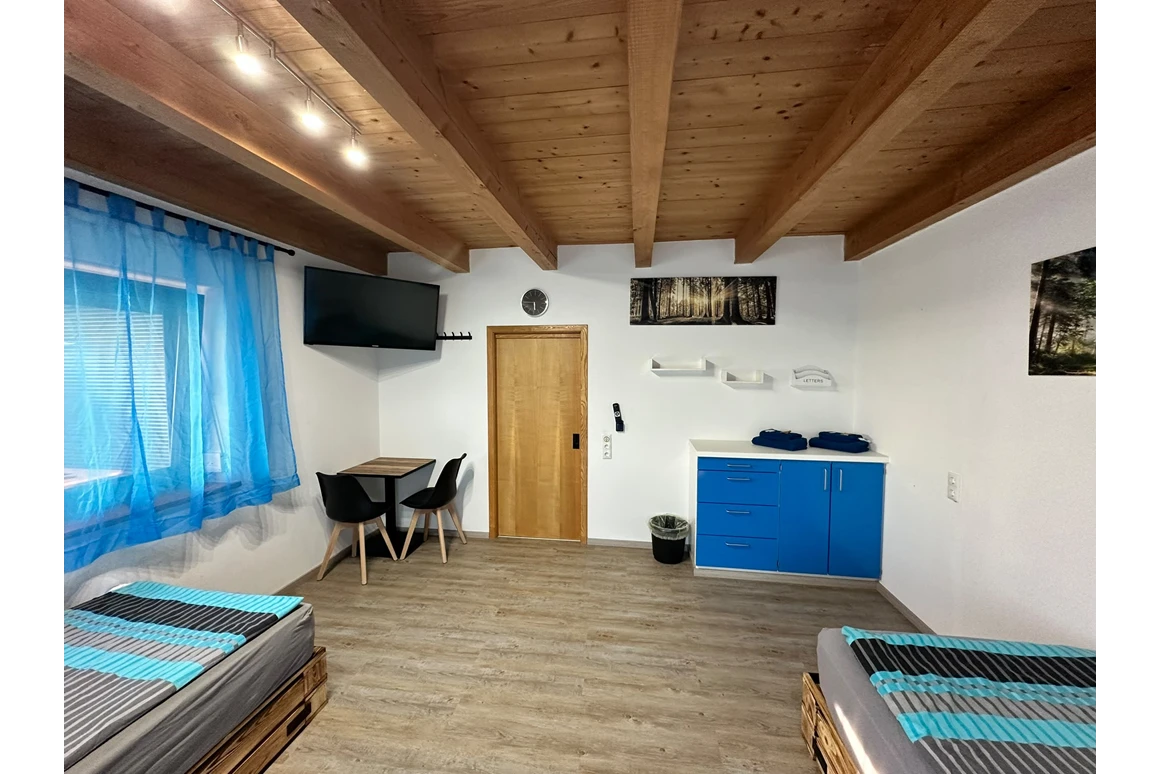 Geräumiges Zimmer mit Holzbalken und blauem Schrank