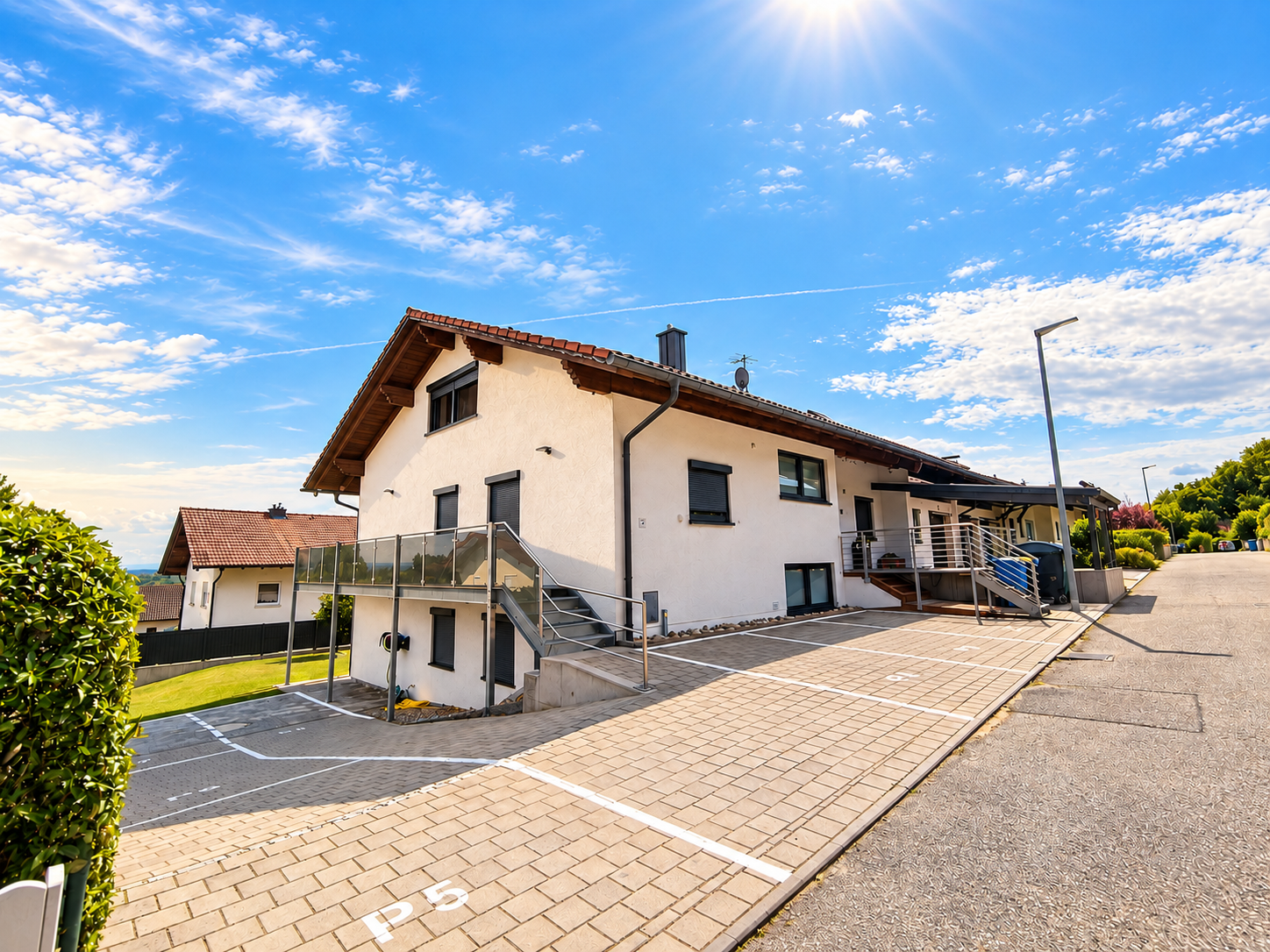 Außenansicht des Haus Alpenblick mit Terrasse und Parkplätzen